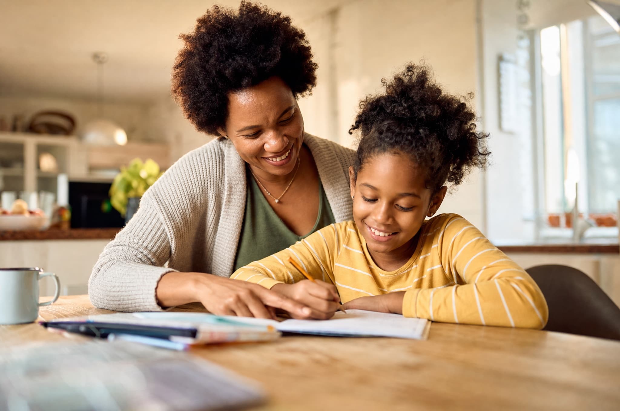A parent and child calmly doing homework together in a supported home